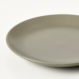 Enkel, rund sideplade med glat, lysegrøn finish. Minimalistisk design, jævn kant.