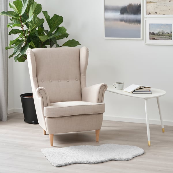 Hyggeligt FÅRDRUP hvidt tæppe under lænestol ved hvidt sidebord & plante.