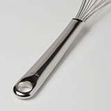 Piskeris i rustfrit stål med poleret, ergonomisk håndtag og hængende hul, der ligger på en ren overflade.