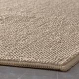 Beige bademåtte med struktur med hævede prikker, mønster og syede kanter.
