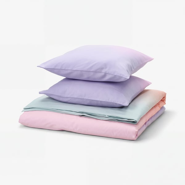 Lilla puder på pastelfarvet sengetøj, blødt design.