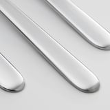Moderne teskefulde arrangeret pænt på en slank overflade. Rustfrit stål, poleret til at reflektere lys, der viser elegant og minimalistisk design.