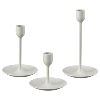 Tre hvide lysestager i varierende højder; moderne design, metalhus med filtbaser.