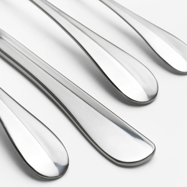 Polerede metalliske skeer arrangeret pænt, reflekterer lys, viser slankt, moderne design og skinnende, holdbar finish.
