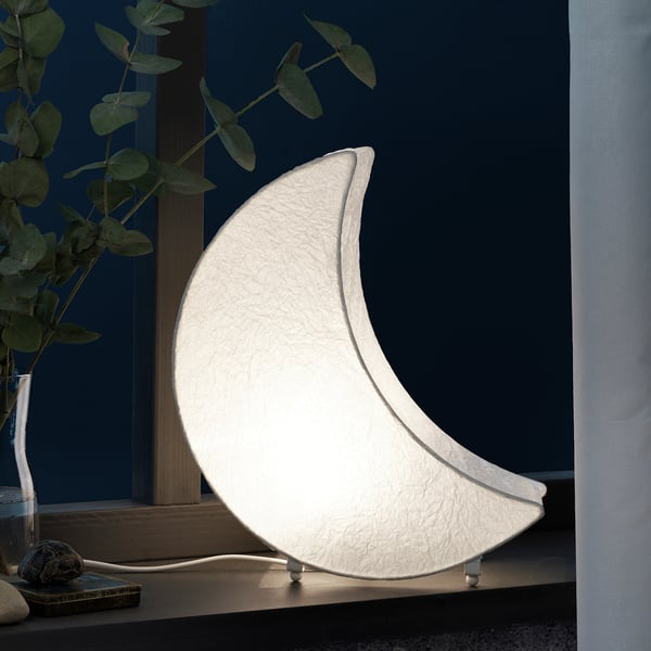 En stilfuld, halvmåneformet led bordlampe, der udsender blødt, varmt lys, ideel til hyggelig atmosfære. Perfekt til indendørs brug og forbedrer festlig indretning.