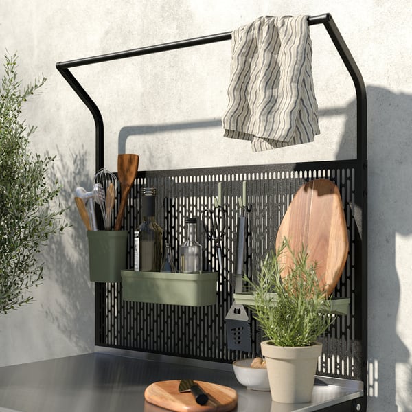 Moderne sort metal køkkengitter med hængende redskaber, håndklæde og planter.