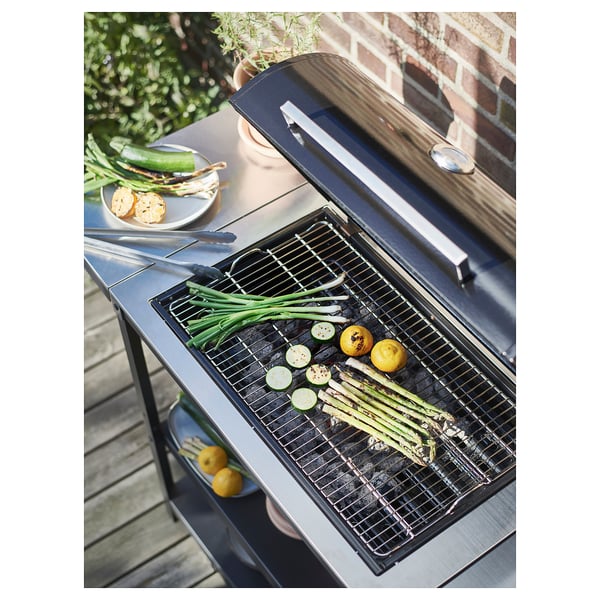 Sort grill med grøntsager og citron; udtrækkeligt sidebord.