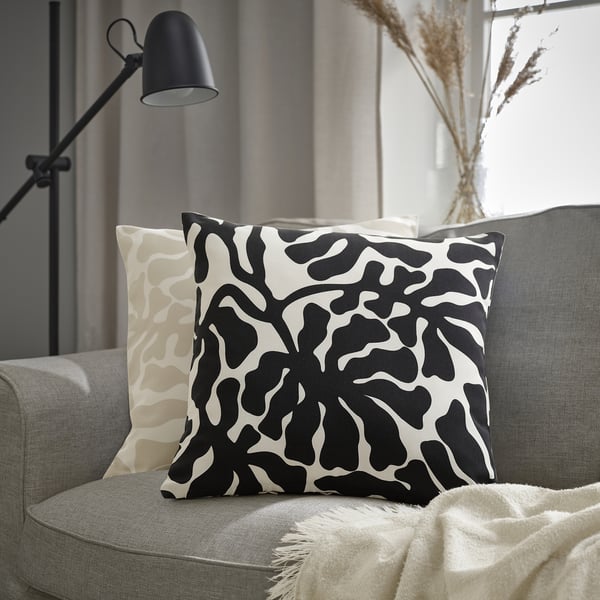 Sort/hvid bladmønstret GRÖNKNAVEL pude på grå sofa. Moderne, stort design.