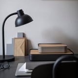 Sort skrivebord med bl.a. HARVMATTA kasse med kork.
