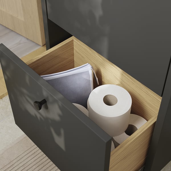En åben badeværelsesskuffe afslører toiletpapirruller og en boks med servietserviet, der viser HAVBÄCKs pladsbesparende opbevaring.
