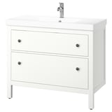 Hvid HEMNES badeværelsesskab med 2 skuffer med sorte knopper, en keramisk vask og et kromarmatur i et slankt, minimalistisk design.
