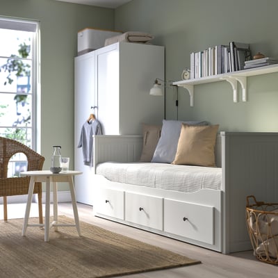Hvid HEMNES daybed med skummadras, tre skuffer og kurvestol.