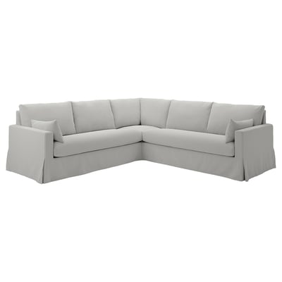 Lysegrå hjørnesofa, rent moderne design med puder, behageligt til afslapning.