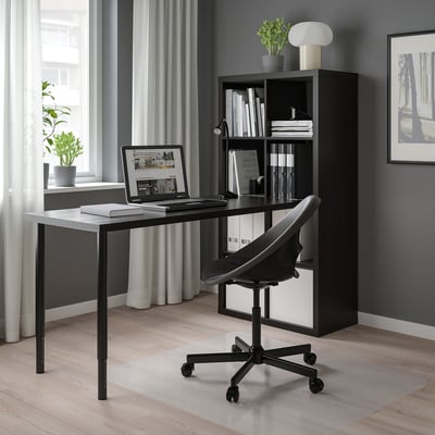 KALLAX sort skrivebordsopsætning mod et vindue med minimalistisk stol og rigelig opbevaringsplads.