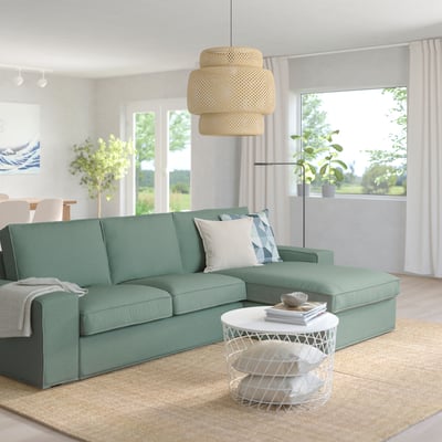 Moderne stue med KIVIK sofa, sofabord, planter og pendel.