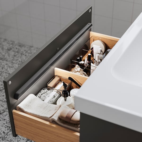 Åben badeværelsesskuffe med pænt organiserede toiletartikler. Blødt lys lyser automatisk, når det åbnes.