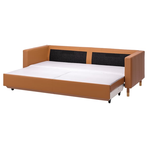 En brunfarvet LANDSKRONA sovesofa med træben og hynder, lavet af læder og stof, i et moderne design.