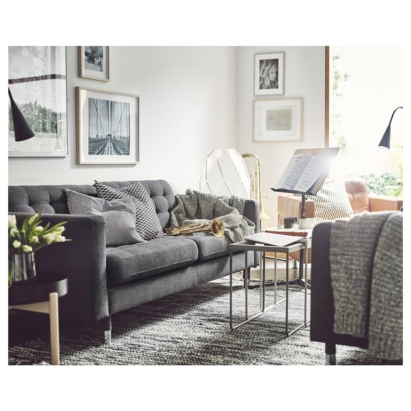 Moderne stue med grå landskröna sofa, puder, bord og kunstværker.