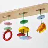 Babygymnastik med farverigt hængende legetøj, der fremmer hånd-øje-koordination og visuel stimulering, perfekt til spædbørn.