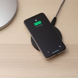 En smartphone, der oplades på en trådløs pude, der viser 97 % opladning, med et usb-c-kabel tilsluttet.