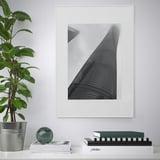 Moderne stue med LOMVIKEN sort/hvid skyskraber fotoramme, metalkant, omgivet af bøger og grønne planter.
