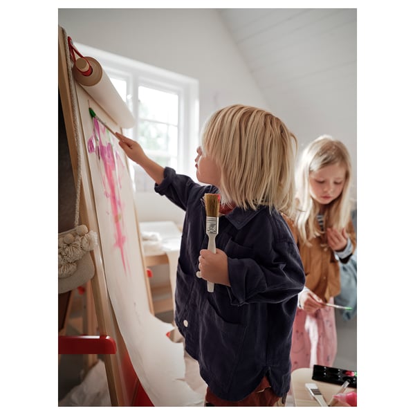 To børn står og maler på et MÅLA staffeli med whiteboards i et lyst rum. Den ene holder en pensel, den anden en pen.