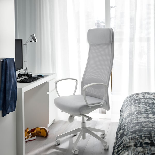 Ergonomisk MARKUS stol ved skrivebordet med skærm, støttende, hjemmekontor, tæt på vindue og seng.