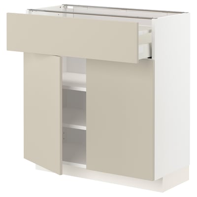 Et hvidt METOD køkkenskab med beige låger og hylder. Den har et moderne design med en glat finish og rene linjer.