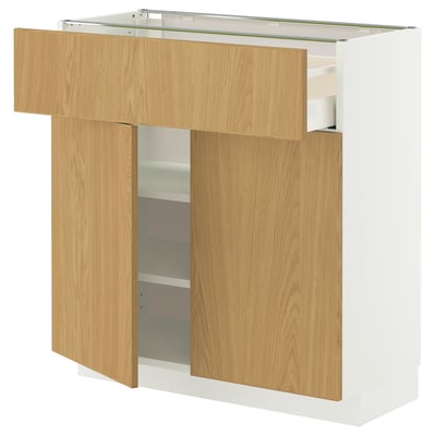 En hvid METOD køkkenenhed med lyse træskuffer og hylder, med et moderne design med et slankt og rent look.