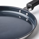 Nærbillede af MIDDAGSMAT-pande, der viser glat, non-stick overflade og behageligt håndtag.