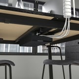 Kabelstyringssystem under bordet, der viser pænt organiserede ledninger og ledninger under et moderne konferencebord.