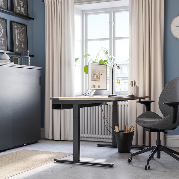 Moderne hjemmekontor: MITTZON sort skrivebord passer pænt under stort vindue, grå stol, beige gardiner, planter, hylder og blå væg.