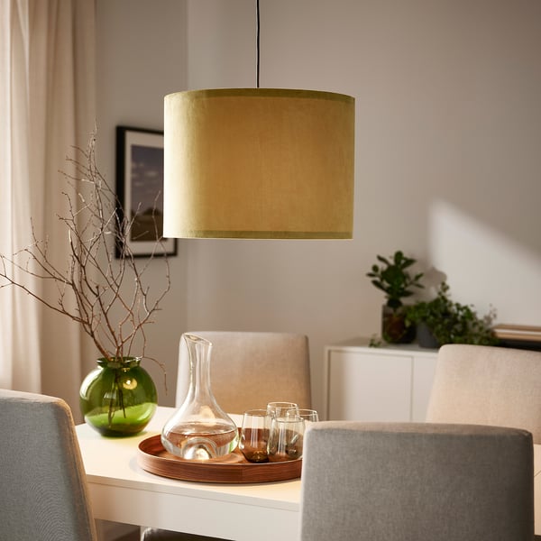 Hyggelig spisestue med MOLNSKIKT lampe, beige stole, grøn vase, karaffel, varmt lys.