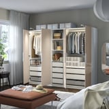 Organiseret garderobe med skuffer, hylder og belysning.