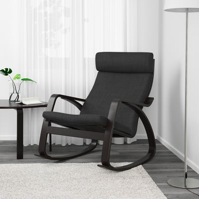 Moderne sort gyngestol med polstret sæde og ryg på let tæppe, ved siden af bord og lampe.