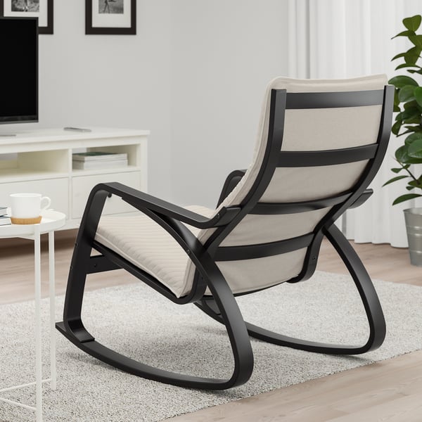 Moderne gyngestol i stuen, sort metalstel, beige hynder, hyggeligt og stilfuldt.