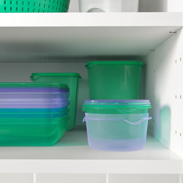 Plastbeholdere i grøn og lilla på hylder, til opbevaring af mad.
