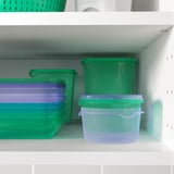 Plastbeholdere i grøn og lilla på hylder, til opbevaring af mad.
