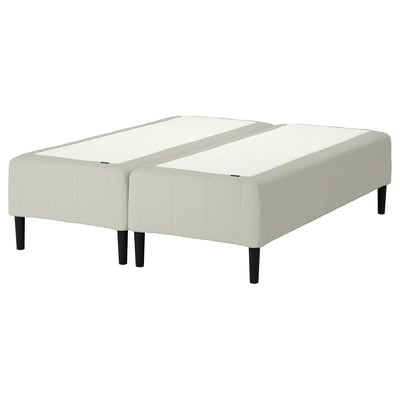 En IKEA RÅHOLMARt dobbeltsengsbund i hvidt stof med træben.