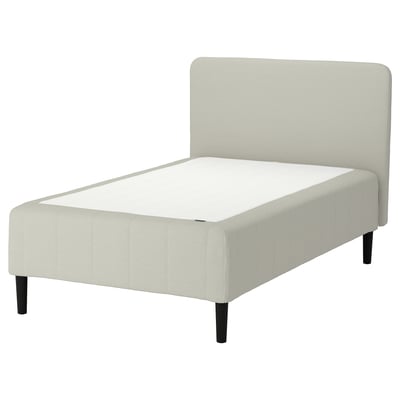 Minimalistisk seng, lysegrå polstring, træben, plys sengegavl.