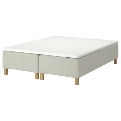 Dette billede viser en RÅHOLMAR sengebund i hvid med træben. Det er et enkelt, moderne design.