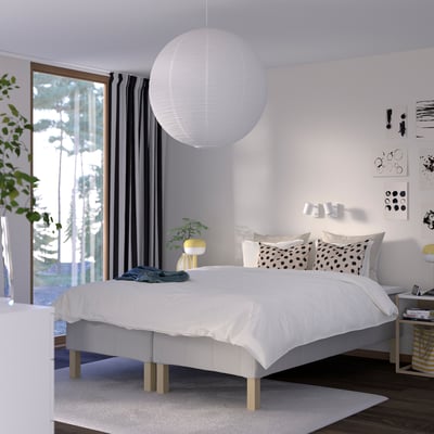 Moderne soveværelse med RÅHOLMAR seng, pendel, natborde, gardiner, kunstværker og planter.