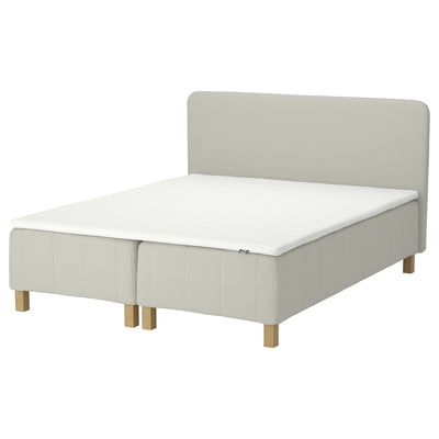 IKEA RÅHOLMAR sengen i hvid med polstret sengegavl og træben.
