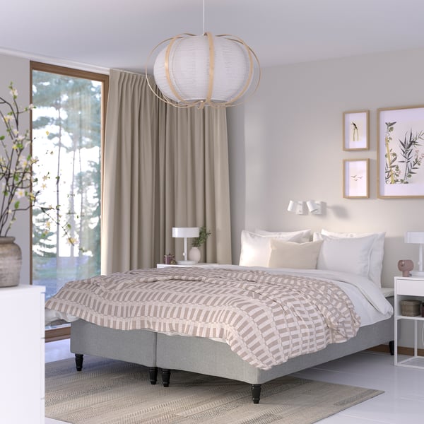 Minimalistisk soveværelse: queensize-seng RÅHOLMAR , beige sengetøj, hvide vægge. Pendel forover, kunst på vægge, gråt tæppe nedenunder.