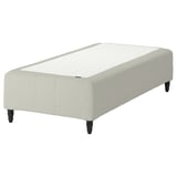 En RÅHOLMAR sengebund i beige med træben. Det har en rektangulær form og polstrede sider for komfort.