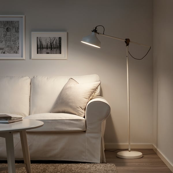 Moderne stue med RANARP lampe over grå sofa, sort-hvid kunst.