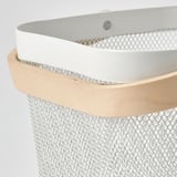 Detalje af stilfuld opbevaringskurv med ventilationshuller, lyst træhåndtag.