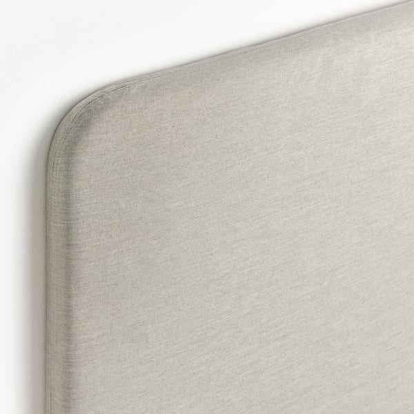 Moderne beige betrukket sengegærde med glat, luksuriøst stof.