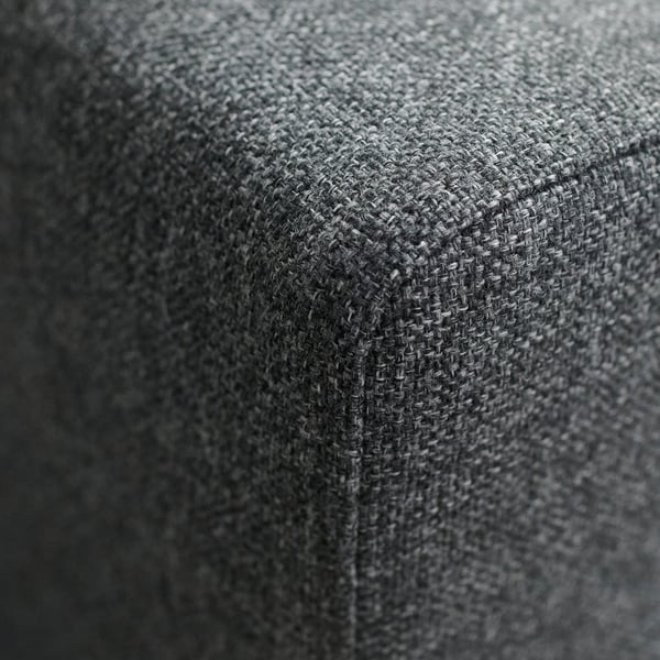 Close-up af et hjørne af sofaen i høj kvalitet med tekstureret stof. Bemærk den indviklede vævning og den holdbare tekstur, hvilket antyder komfort og lang levetid.