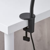 Moderne lampe fastspændt til skrivebordskanten, justerbar hals og sort klemme, kvalitetsdesign.